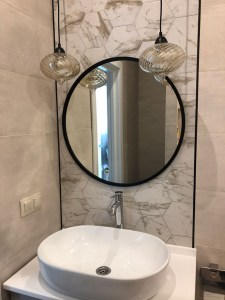 Круглое черное матовое зеркало в интерьере ванной комнаты
