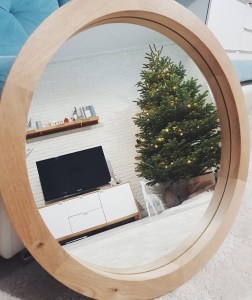 Круглое зеркало в раме из дерева в интерьере столовой или гостиной в скандинавском стиле